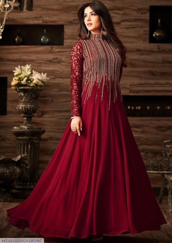 Elegant maroon anarkali dress with gold embroidery and sheer lace sleeves, displayed in a refined indoor setting—featured in Red White Deals for festive and formal wear.
